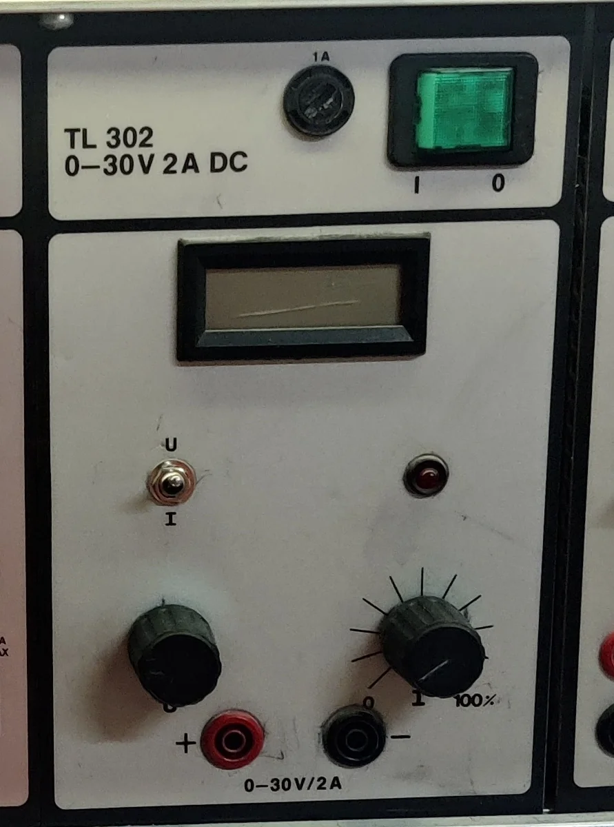 Elektroniikkapöytään asennettu TL 302 -virtalähde; etupaneelissa lukee 0–30 V / 2 A DC.